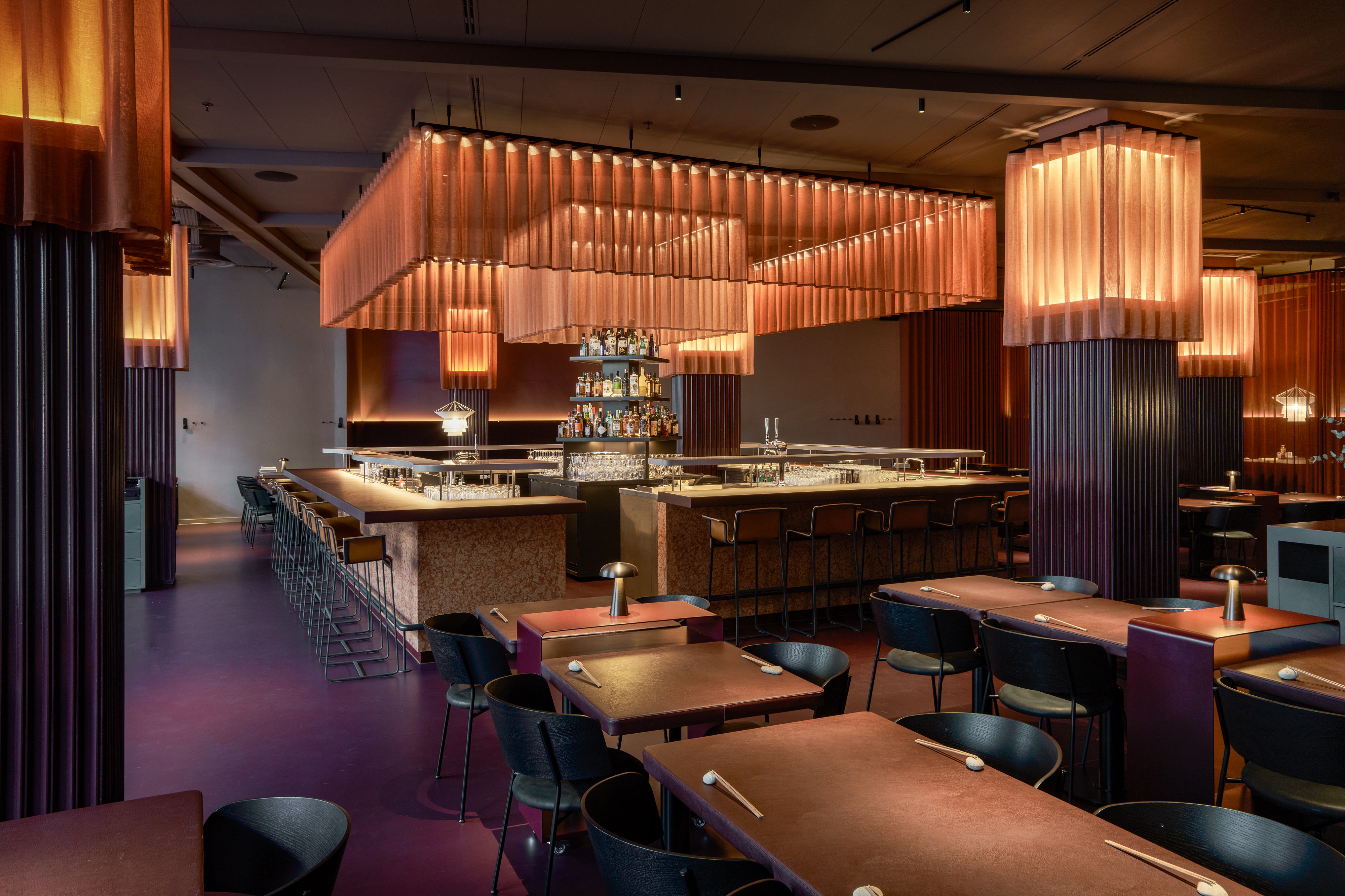 Elegant bar and dining area at One Hundred Shoreditch, featuring warm lighting and a modern aesthetic.