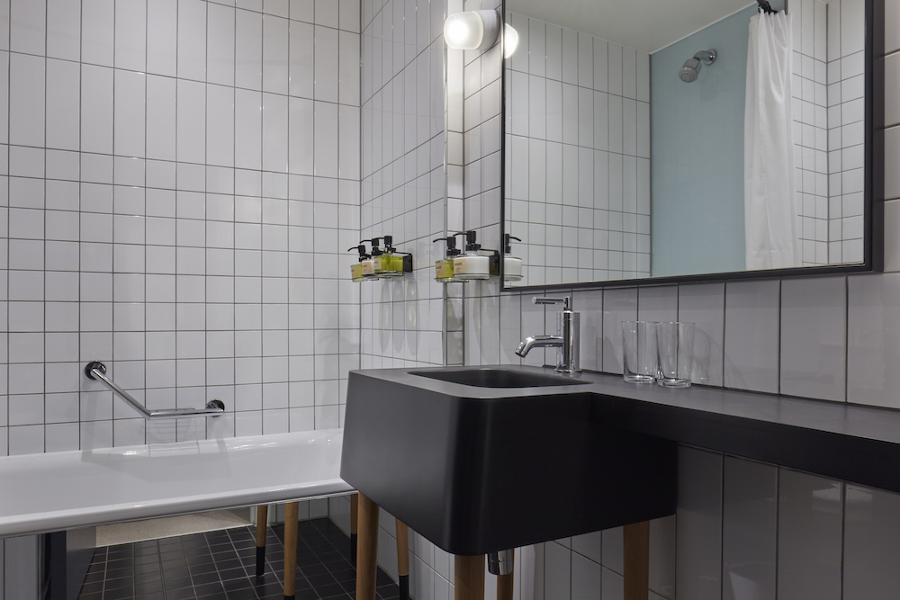 Elegant bathroom showcasing a black and white tiled wall, enhancing the contemporary design of the space.