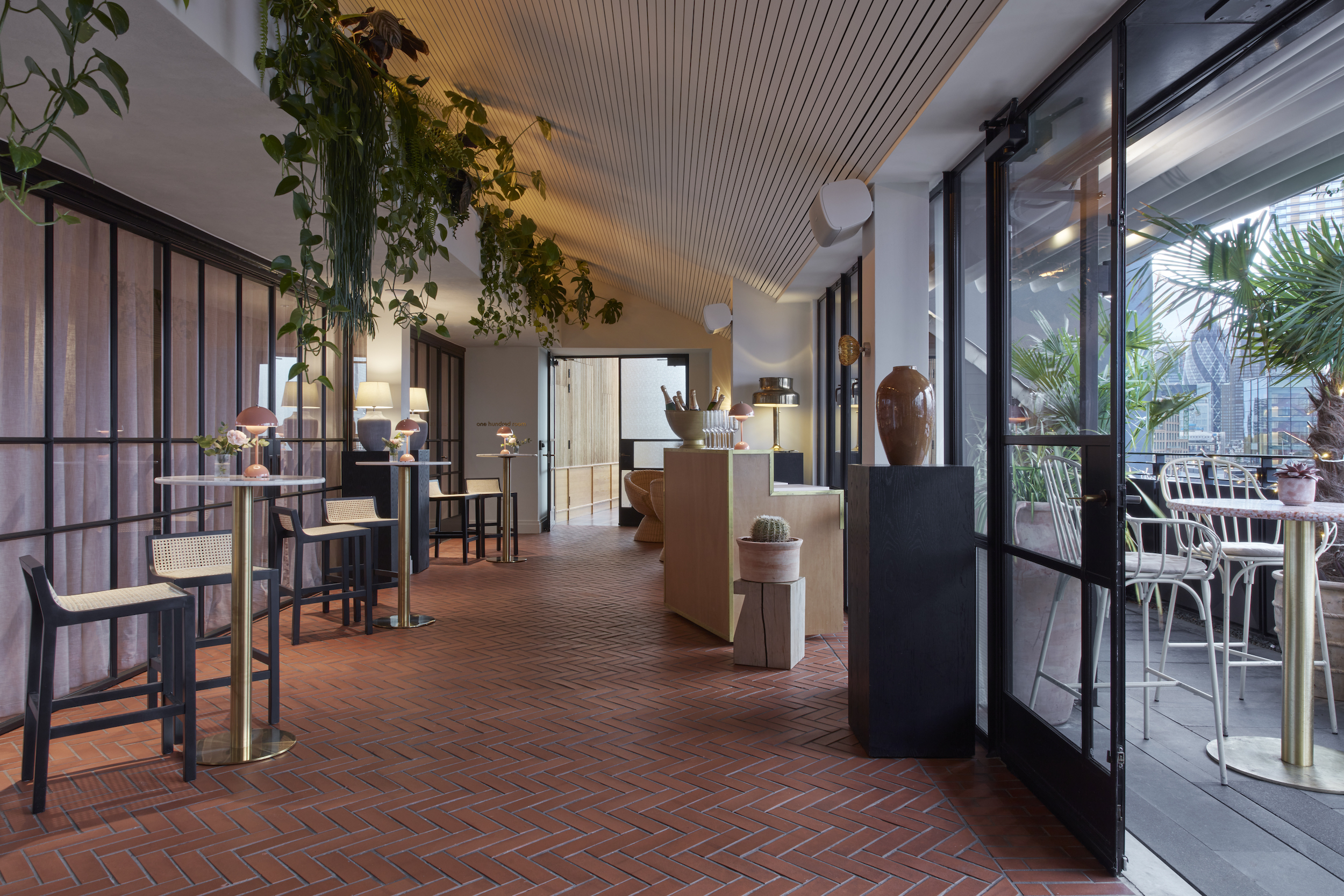 A restaurant featuring a large glass door and an expansive table, inviting guests to enjoy a communal dining experience.