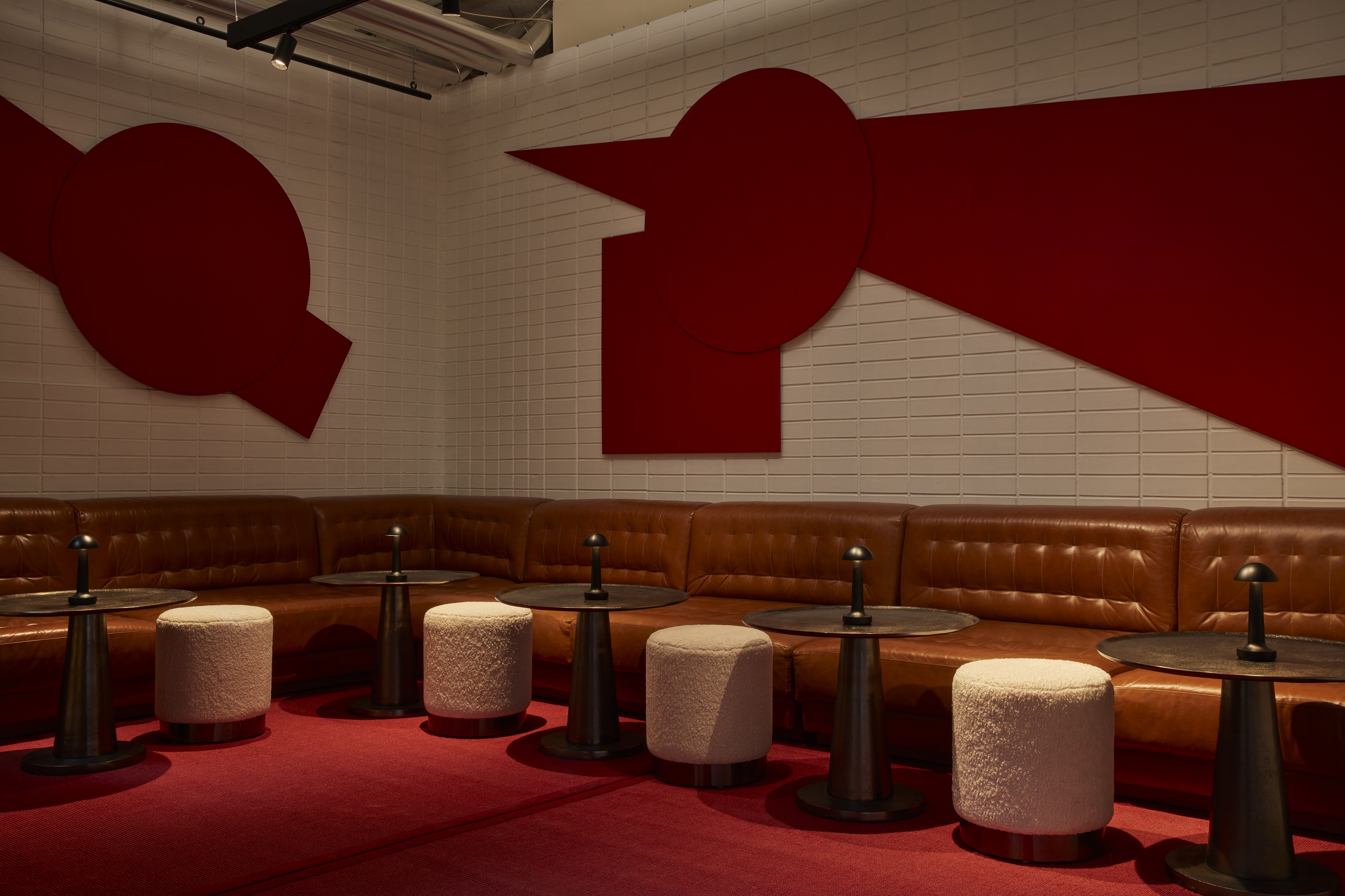 A red and white lounge bar featuring a striking red wall, creating a bold and vibrant atmosphere.