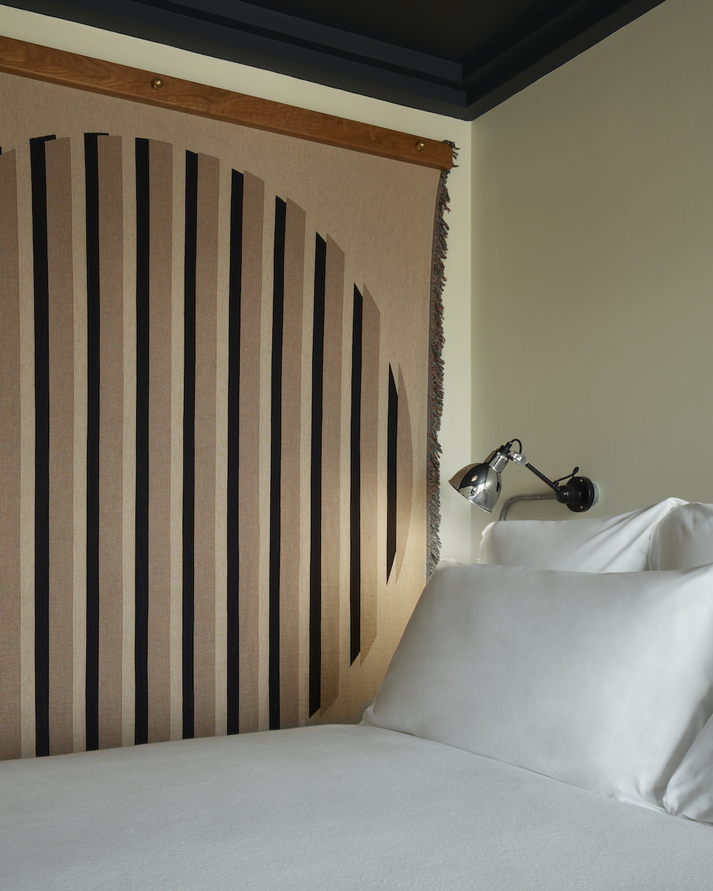 A neatly made bed featuring crisp white sheets and fluffy pillows, creating a serene and inviting atmosphere.