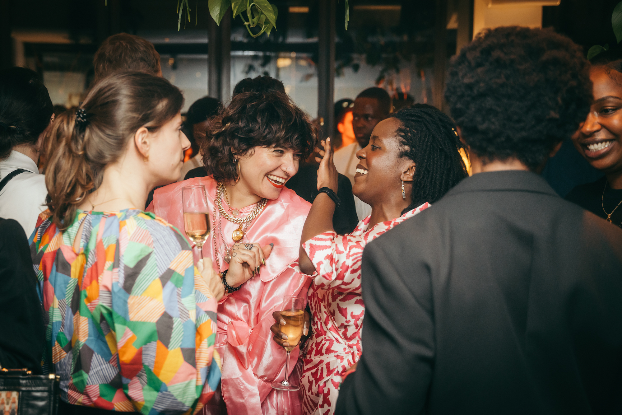 A group of women engaged in lively conversation at a festive gathering, enjoying each other's company at a party.