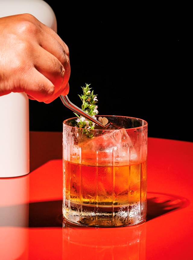 Hand stirring cocktail glass