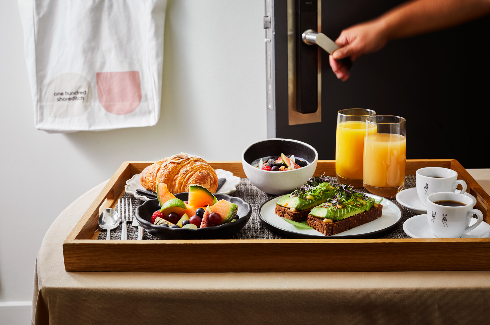 A tray filled with a variety of breakfast items, including eggs, toast, and fruit, set for a morning meal.