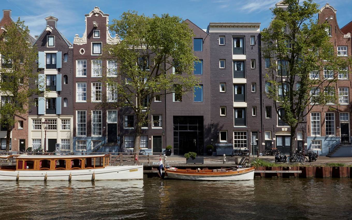 A scenic view of buildings lining the water's edge, accompanied by several boats gently floating nearby.